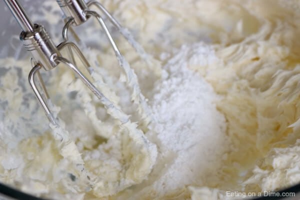 The cream cheese and the powdered sugar being mixed together. 