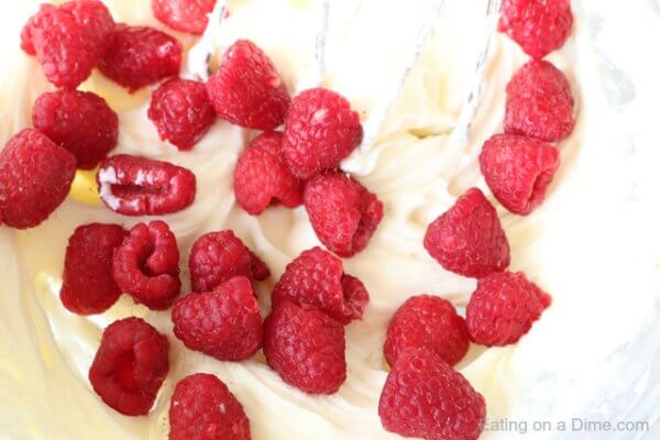 The fresh raspberries being mixed into the dip 