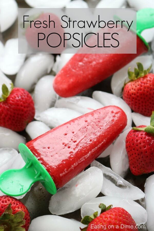 Strawberry popsicles are the perfect treat to make this Summer. Strawberry popsicles recipe tastes so refreshing. Try this fresh strawberry popsicle! Close up image of strawberry popsicle on ice with fresh strawberries on the side.
