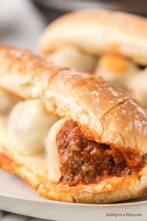 close up image of meatball subs on a white plate. 