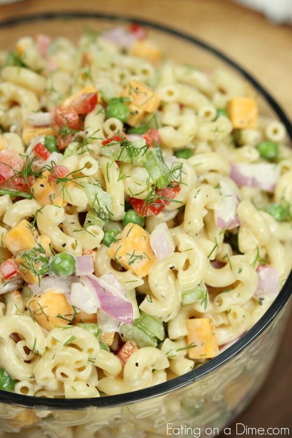Close up of Creamy Macaroni Salad in a large bowl topped with fresh dill 