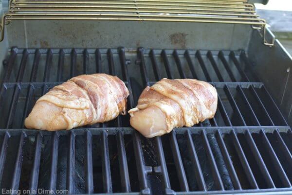 Placing the bacon wrapped chicken on the grill