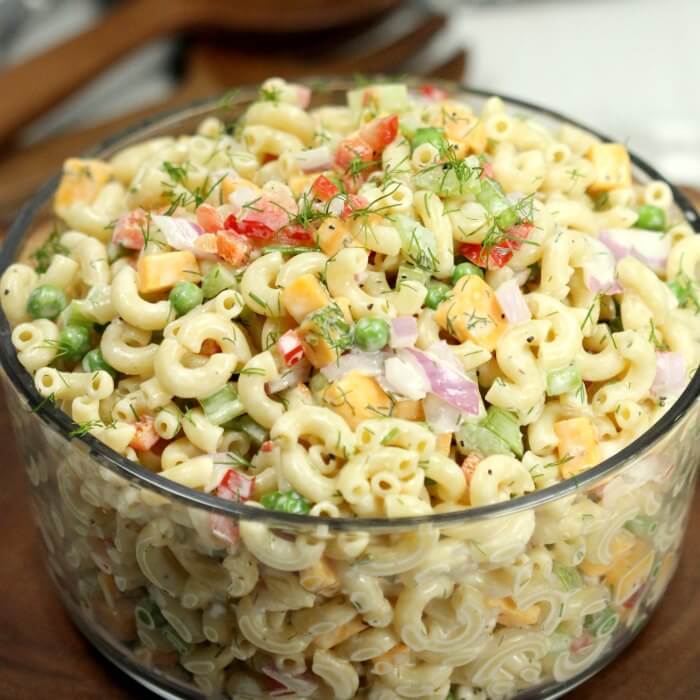 Creamy Macaroni Salad in a large bowl topped with fresh dill 