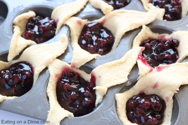 Blueberry Pie filling in each muffin tin with crescent rolls.