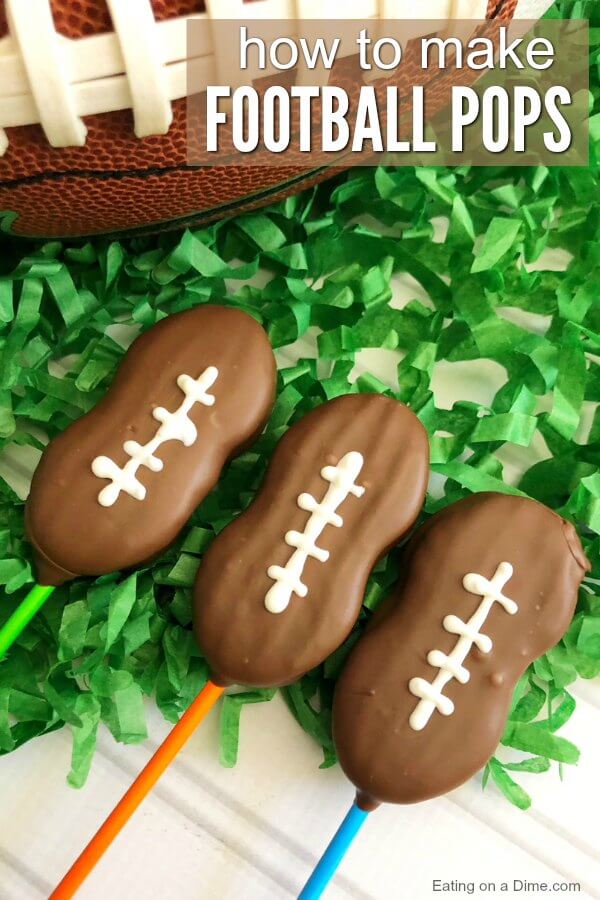 Close up image of football cookie pops on green confetti. 