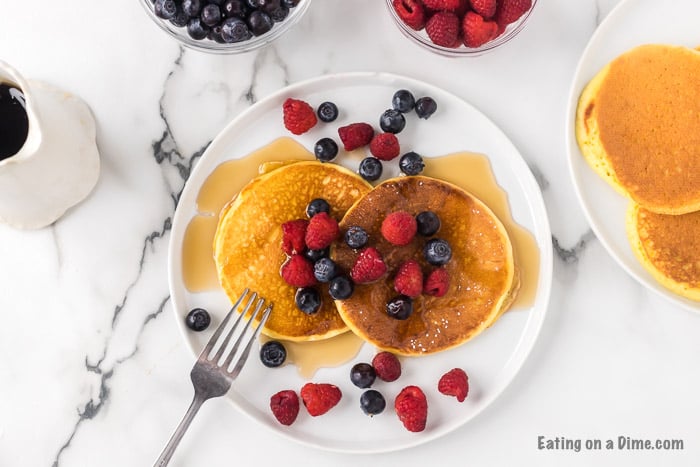 pancakes on a plate with syrup and berries
