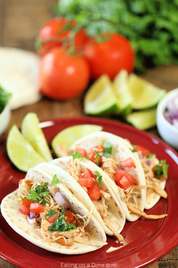 Close up image of chicken ranch tacos on a red plate. 