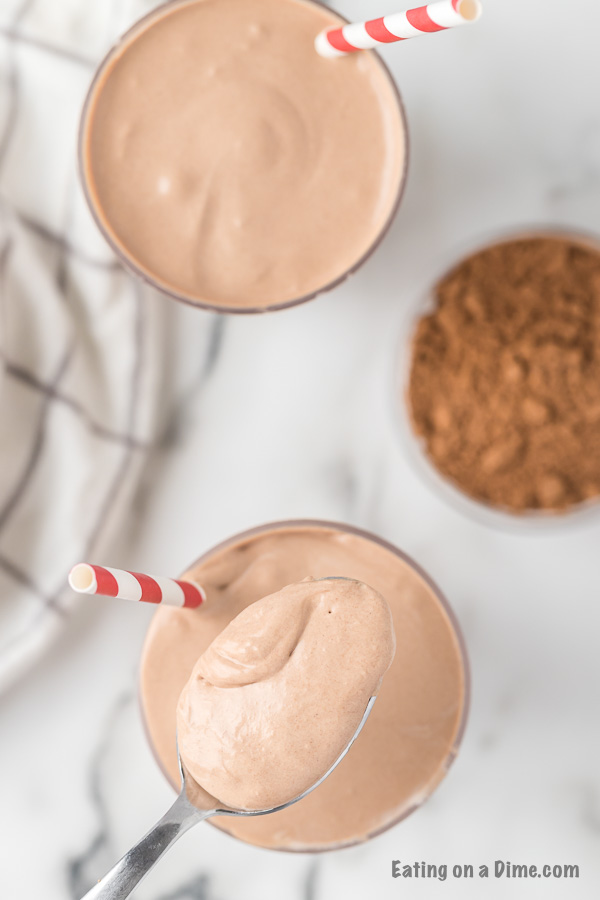 Close up image of chocolate shake with a serving on a spoon. 