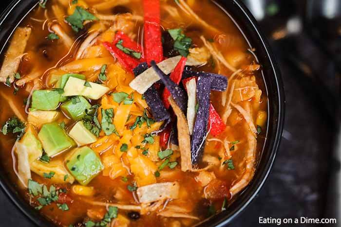 Crockpot Chicken Tortilla Soup Recipe is the best comfort food and it is so simple to make in the slow cooker. This recipe can feed a crowd! Chicken Tortilla in a bowl topped with tortilla chips and diced avocado