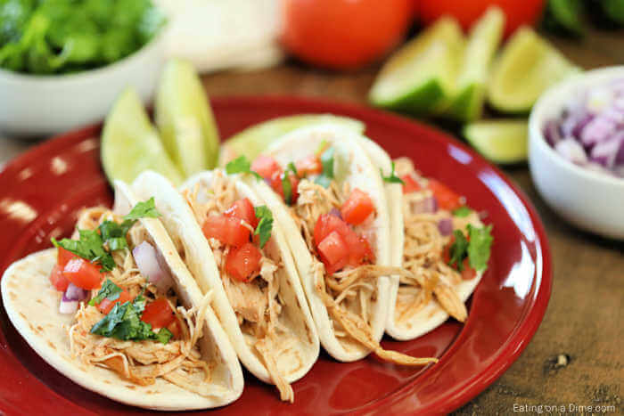 Close up image of chicken ranch tacos on a red plate. 