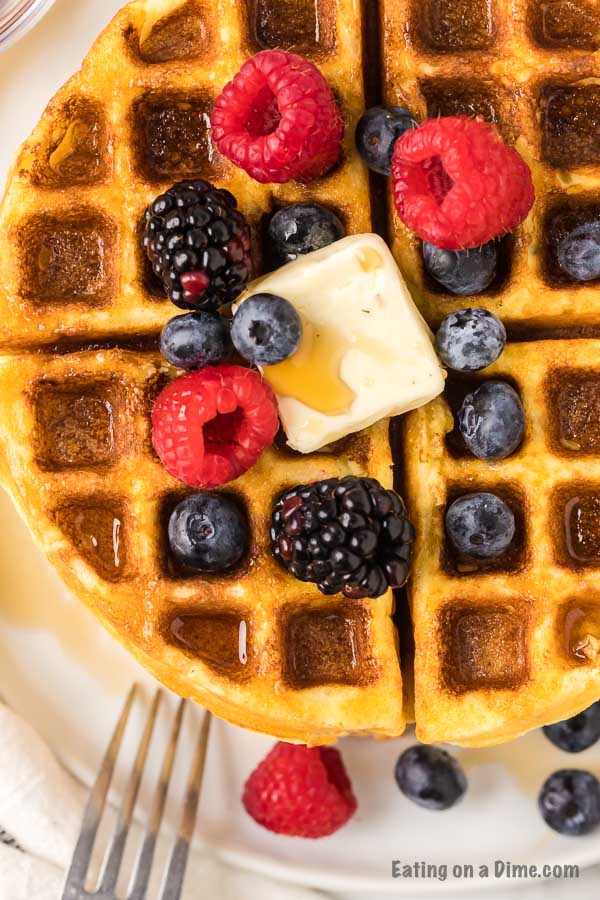 Keto waffle on plate topped with fruit and butter.