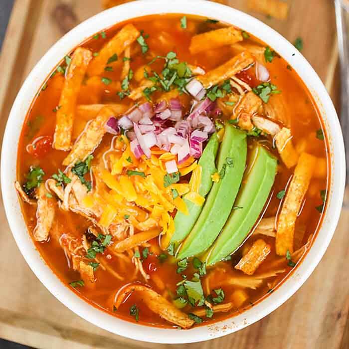 Close up image of chicken tortilla soup in a white bowl. 