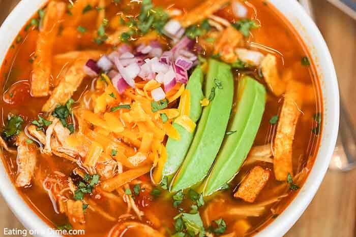 Close up image of chicken tortilla soup in a white bowl. 