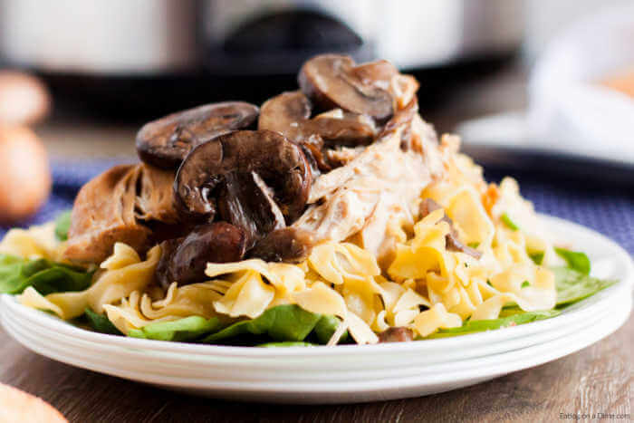 serving of chicken marsala on a white plate with pasta.