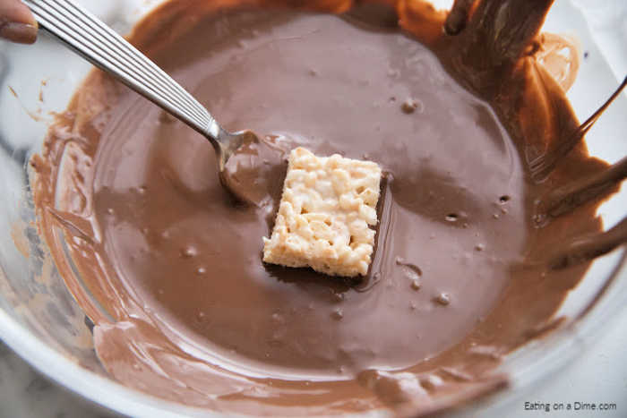 melted chocolate with rice krispies treats dipped in it