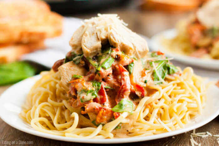 Close up image of Creamy Tuscan Chicken on a plate with pasta. 