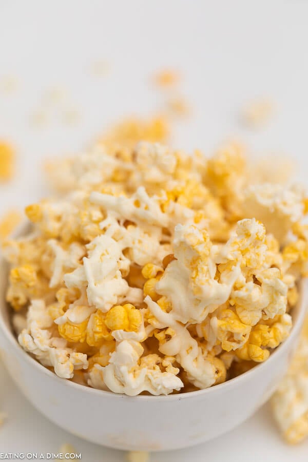 Popcorn covered in white chocolate in a small white bowl 