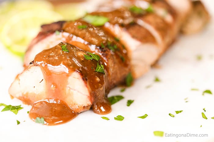 Sliced Pork Tenderloin topped with a honey lime sauce with sliced limes next to it.  