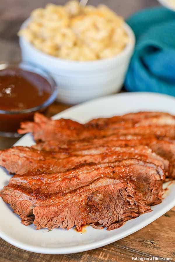 Close up image of slice brisket on a white plate. 