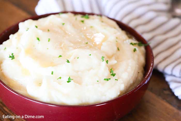 Close up image of mashed potatoes in a red bowl. 