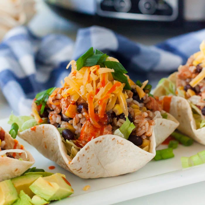 Chicken Burrito Bowl in a flour tortilla topped with chicken and green onions