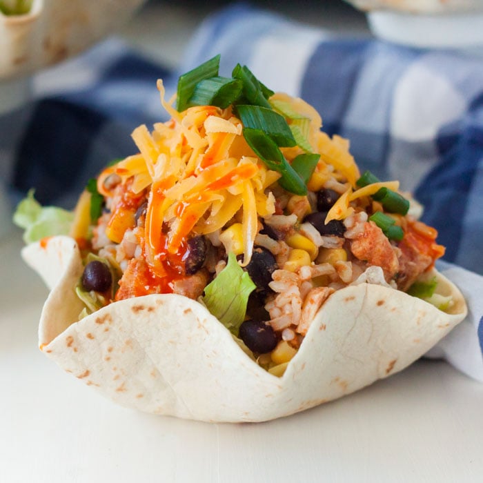 Chicken Burrito Bowl in a flour tortilla topped with chicken and green onions