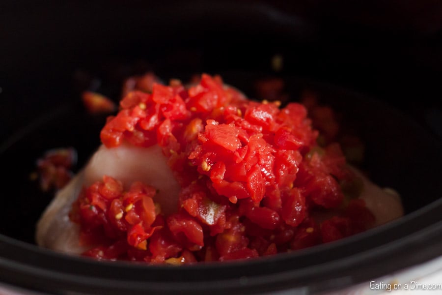 Adding the chicken and diced tomatoes to the slow cooker