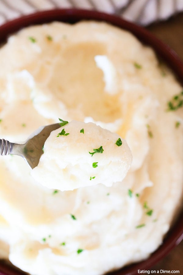 Close up image of mashed potatoes with a serving on a spoon. 