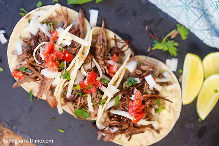 Beef Carnitas Tacos on a platter with a side of fresh limes