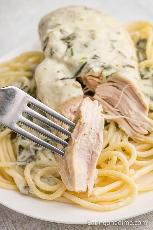 Chicken Florentine over pasta on a plate with a fork