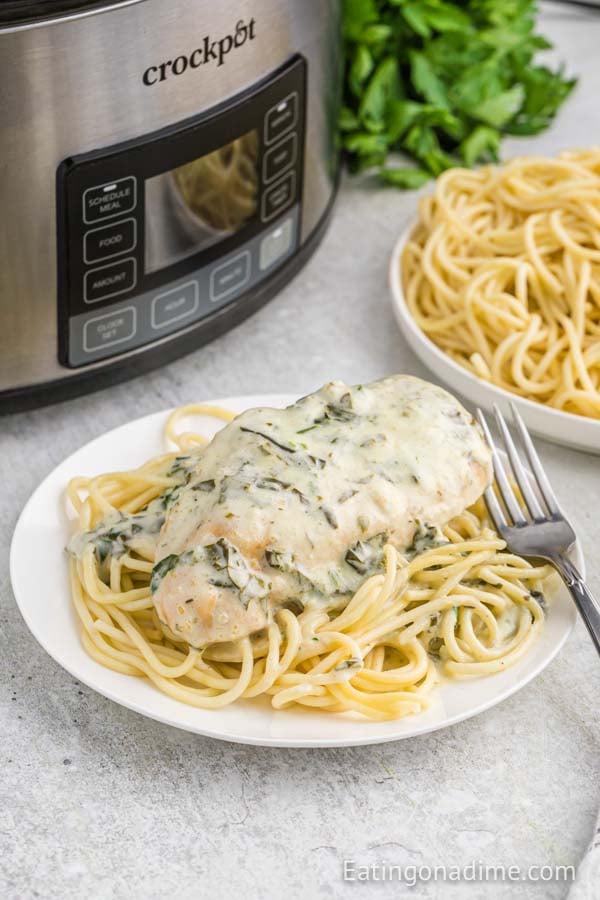 Chicken Florentine over pasta on a plate with a fork