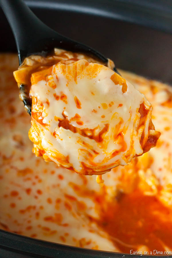 A serving of buffalo chicken enchilada on a spoon from the crock pot