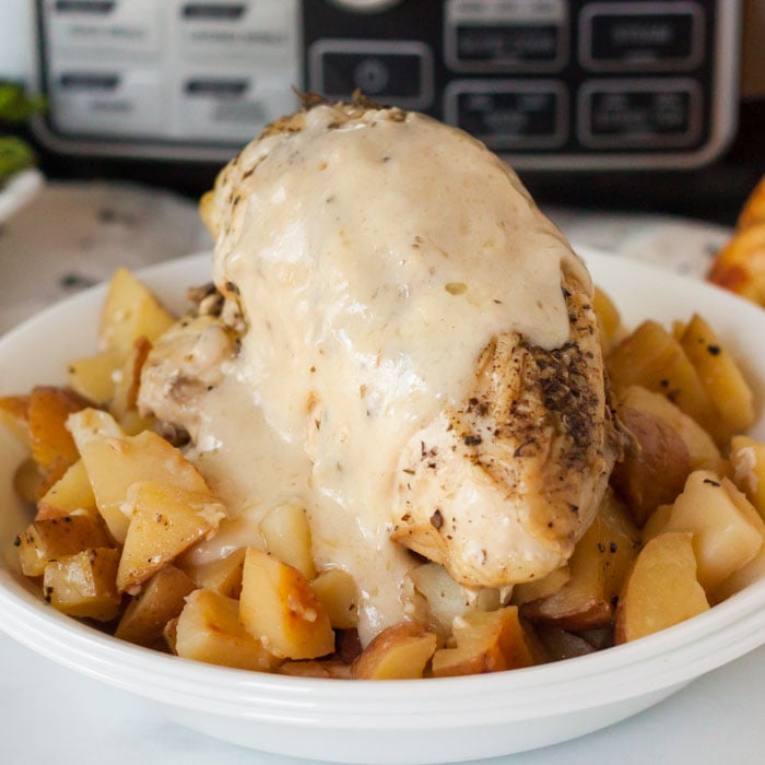 Lemon Garlic Chicken over potatoes with a creamy sauce on top.