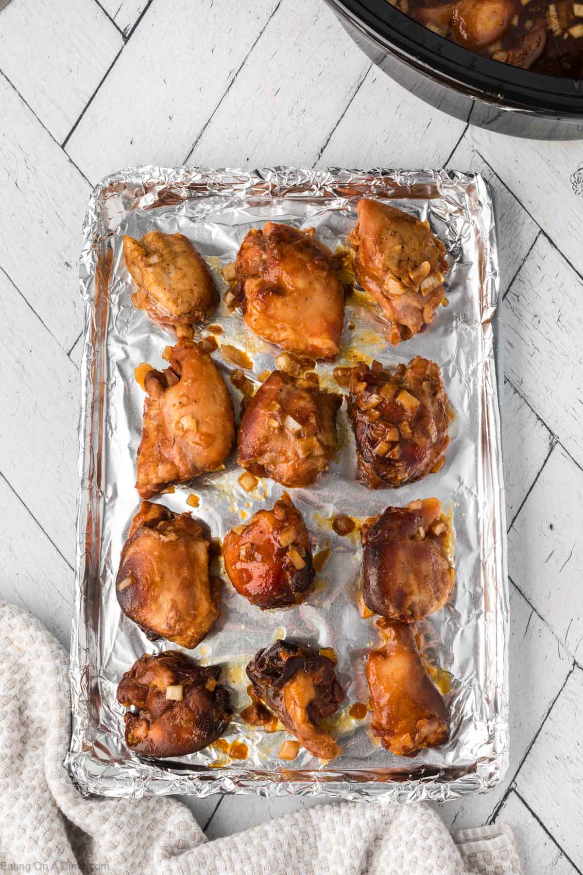 Placing the chicken on a baking sheet lined with foil to broil in the oven