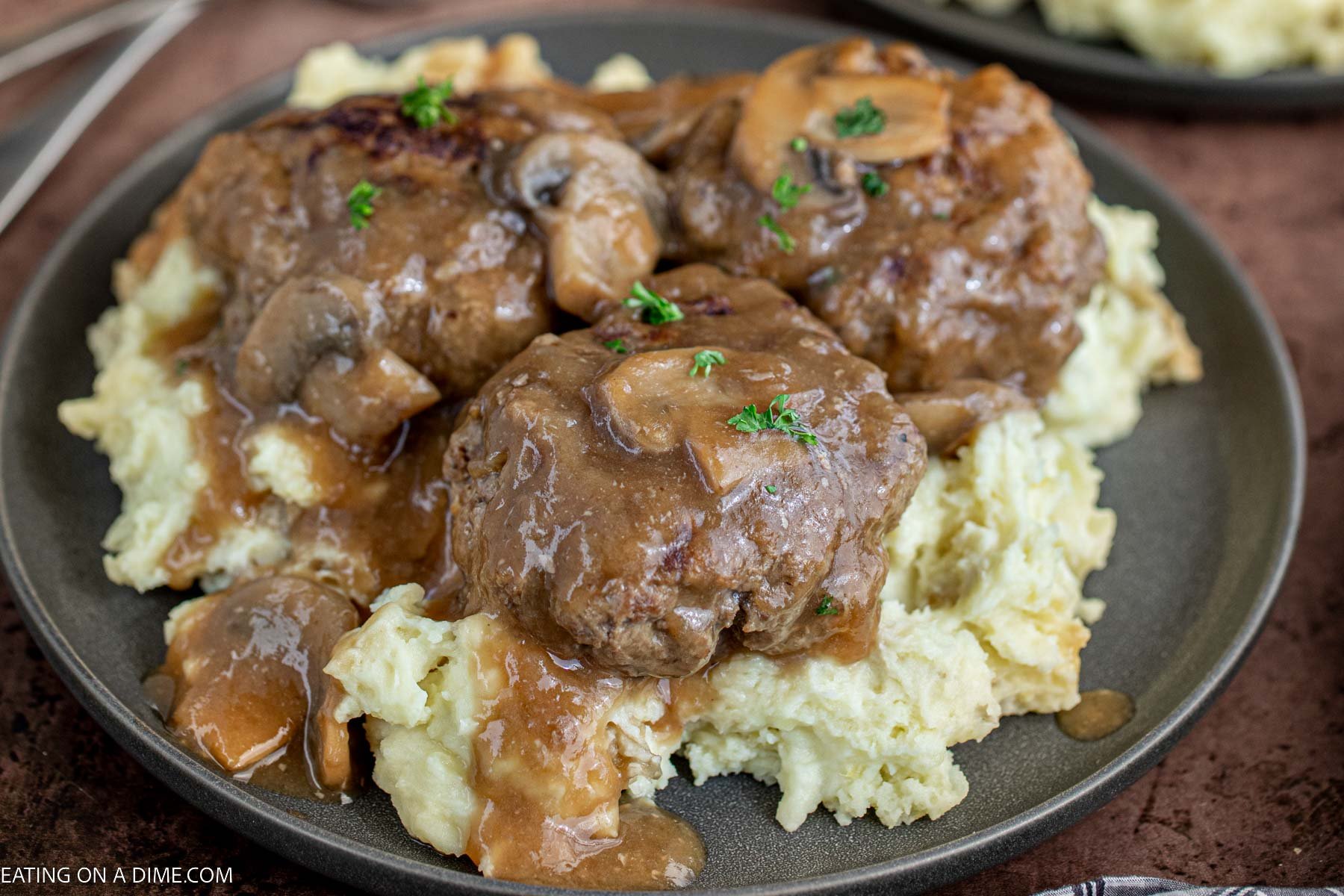 Salisbury Steak over mashed potatoes on a plate