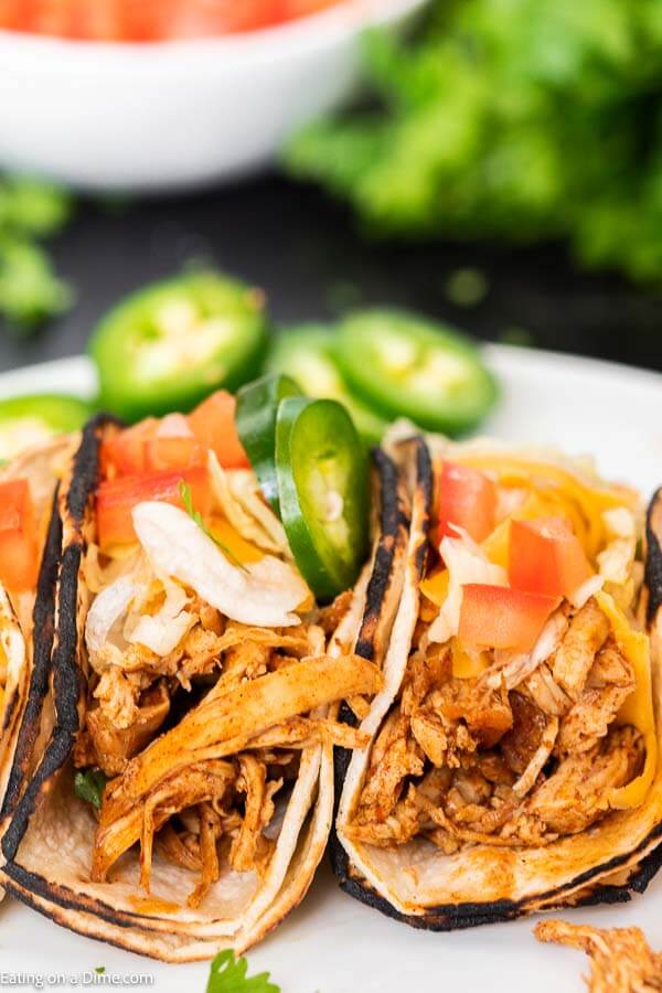 You're going to love this healthy instant pot chicken tacos. This is one of my favorite pressure cooker recipes. This 3 ingredient shredded electric pressure cooker chicken tacos with salsa and taco seasoning is easy to make! You can even make chicken tacos from frozen with this easy recipe that is truly the best! This instant pot recipes easy chicken is perfect for tacos and taco bowls! The entire family will love it! #eatingonadime #instantpotrecipes #pressurecookerrecipes #chickentacos #shreddedchickentacos 