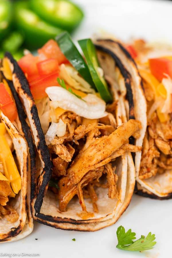 You're going to love this healthy instant pot chicken tacos. This is one of my favorite pressure cooker recipes. This 3 ingredient shredded electric pressure cooker chicken tacos with salsa and taco seasoning is easy to make! You can even make chicken tacos from frozen with this easy recipe that is truly the best! This instant pot recipes easy chicken is perfect for tacos and taco bowls! The entire family will love it! #eatingonadime #instantpotrecipes #pressurecookerrecipes #chickentacos #shreddedchickentacos 