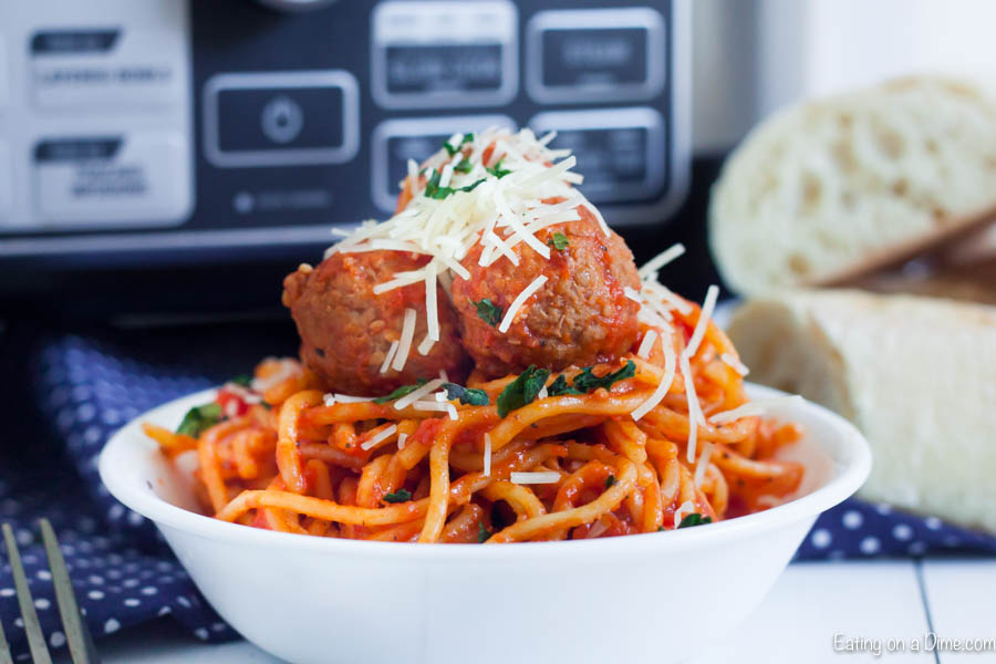 Spaghetti and Meatballs in a bowl topped with shredded parmesan cheese