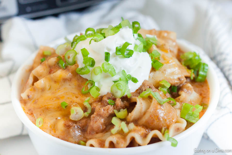 Mexican Lasagna in a bowl topped with sour cream and green onions