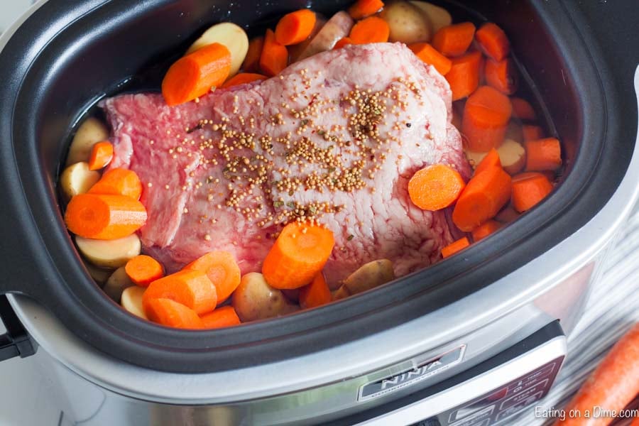 The beef, potatoes, carrots, water and seasoning packet in a crock pot.  