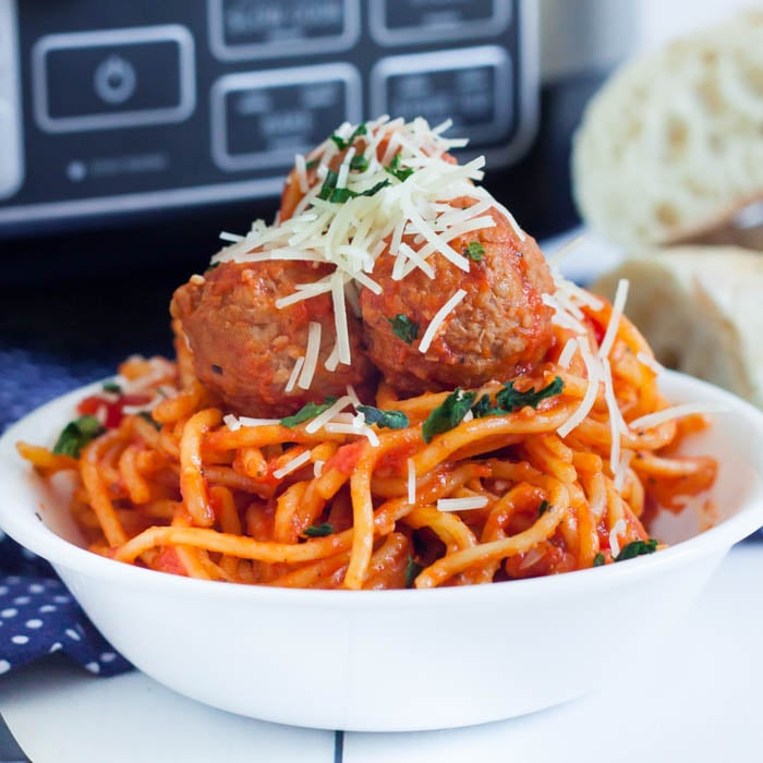 Spaghetti and Meatballs in a bowl topped with shredded parmesan cheese