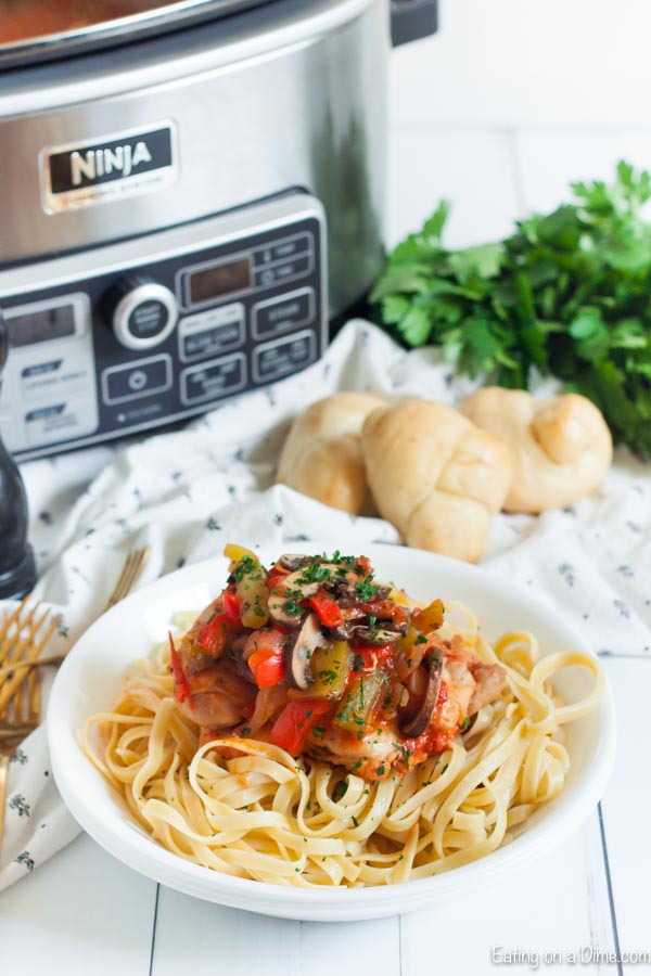Chicken Cacciatore served over fettuccini noodles in a bowl 