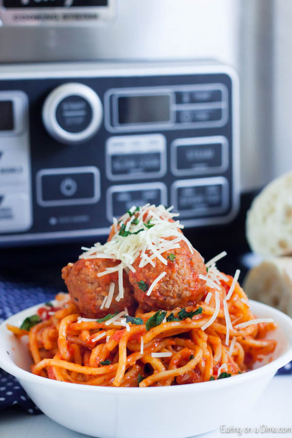 Spaghetti and Meatballs in a bowl topped with shredded parmesan cheese