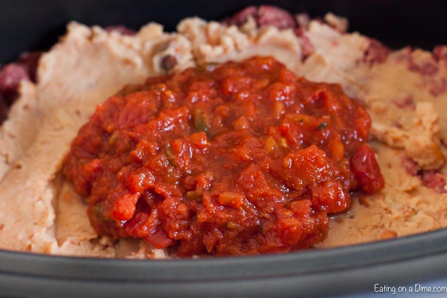 Layering the beef, refried beans and salsa in the slow cooker