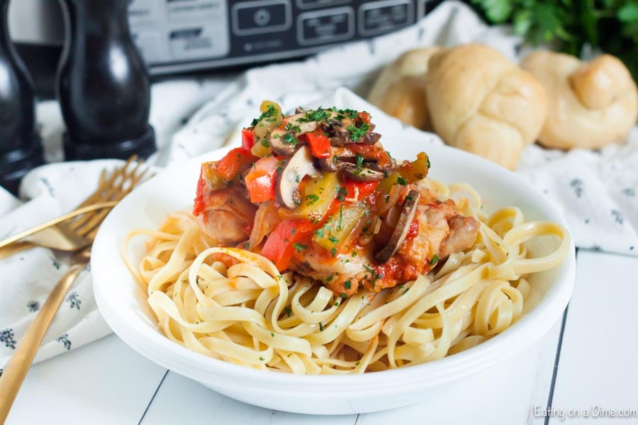 Chicken Cacciatore served over fettuccini noodles in a bowl 