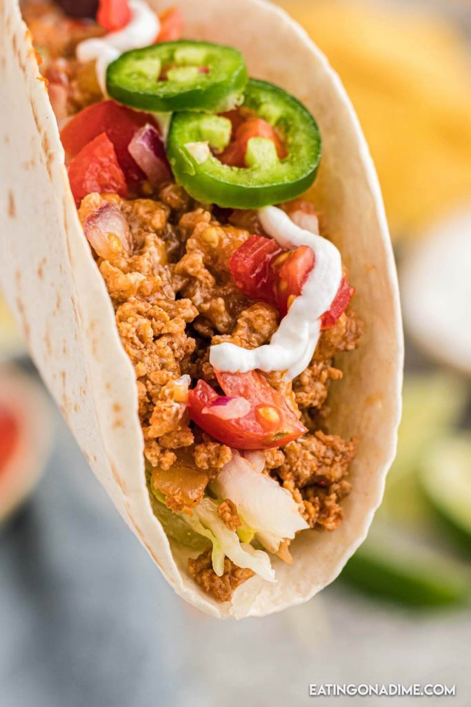 Ground Chicken Tacos topped with jalapenos sour cream and tomatoes