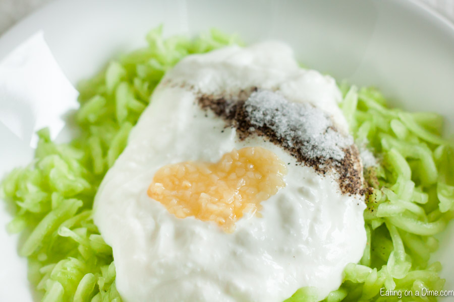 Close up image of shredded cucumber and greek yogurt with minced garlic and spices. 