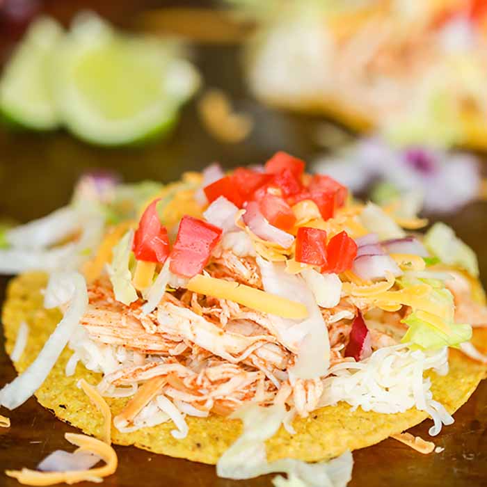 Crock pot chicken tostadas recipe gets dinner on the table fast for a great meal. This recipe is versatile and works for family dinner, parties and more. 