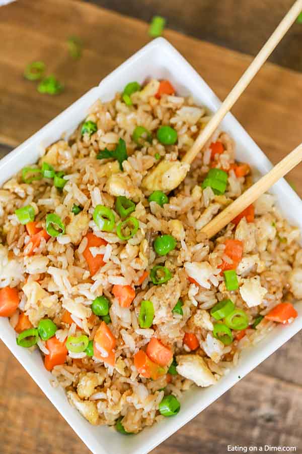 Large bowl of fried rice with chop sticks in the rice. 