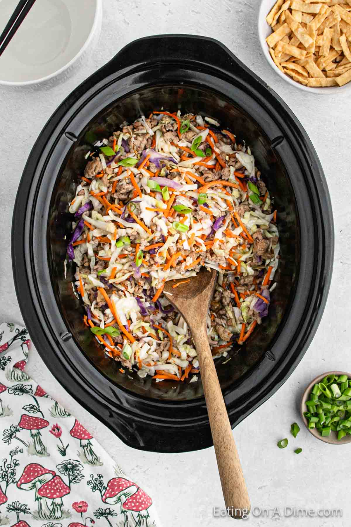 Egg Roll in a bowl in the slow cooker with a wooden spoon